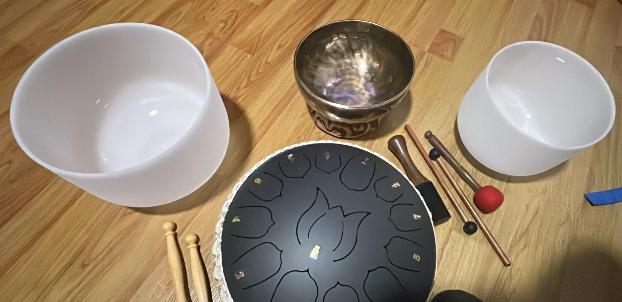 Cuencos de cuarzo, cuenco metálico y tambor de lenguas preparados para una experiencia sonora